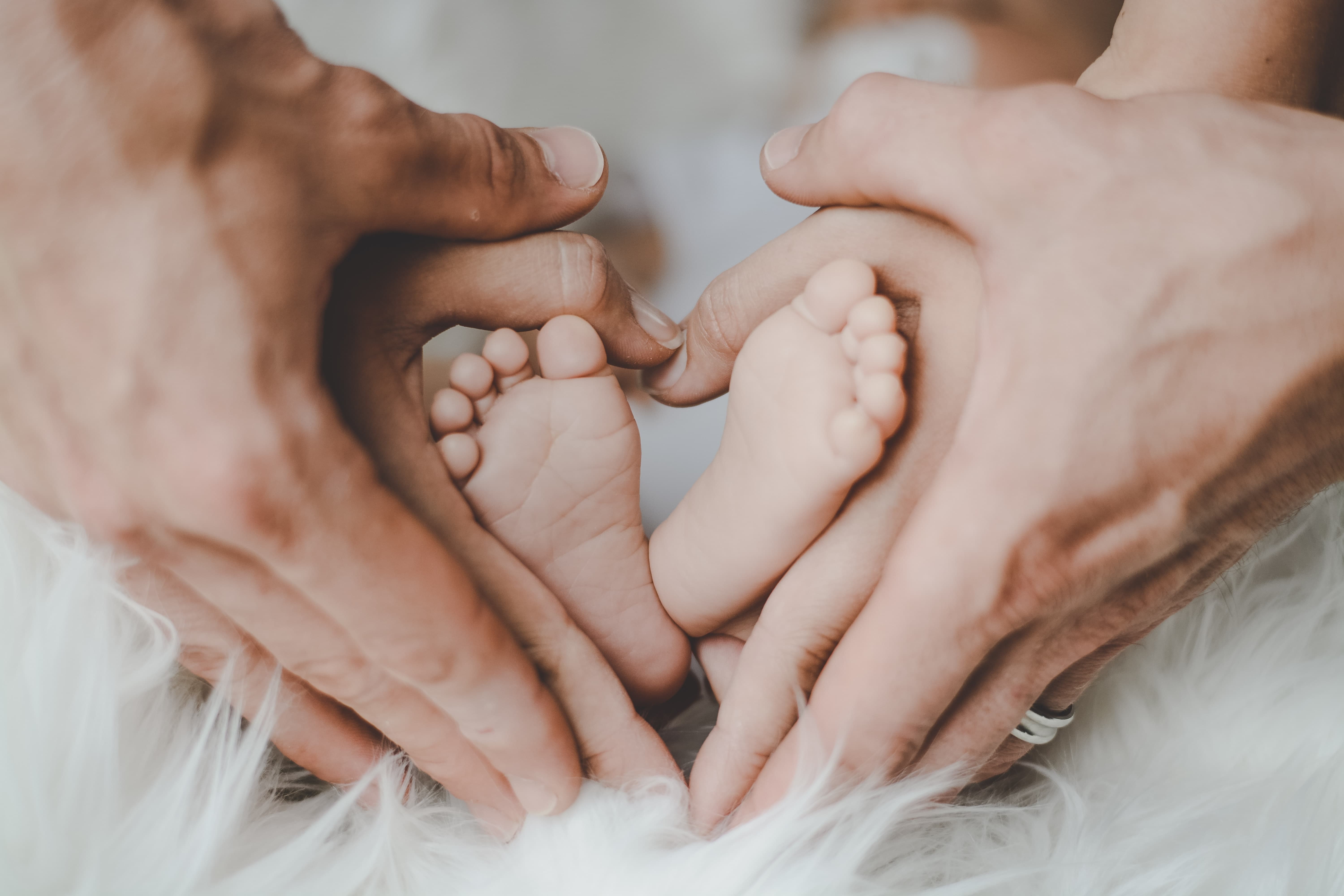 Mother and Father holding baby's feet fertility